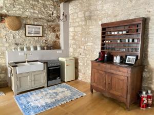 a kitchen with a sink and a stove and a counter at Gorgeous old house in the centre of Souillac in Souillac
