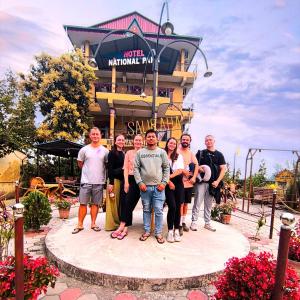 a group of people standing in front of a building at Hotel National Park- A Peaceful Family Home in Sauraha in Chitwan