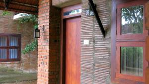 a brick building with a wooden door on it at Clayfingers Art Cottage in Trichūr