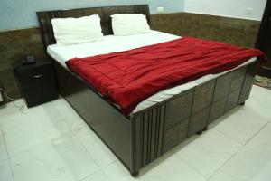 uma cama com um cobertor vermelho em cima em MID CITY HOTEL & RESTO em Chandīgarh