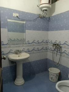un bagno blu e bianco con lavandino e doccia di MID CITY HOTEL & RESTO a Chandīgarh