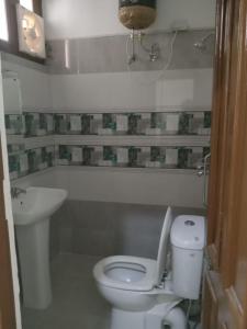 een badkamer met een wit toilet en een wastafel bij MID CITY HOTEL & RESTO in Chandīgarh