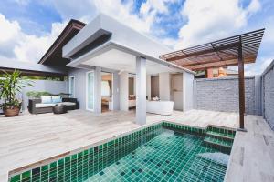 uma villa com uma piscina e uma casa em Twin Lotus Resort and Spa - SHA Plus - Adult Only Hotel em Ko Lanta