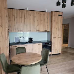 een keuken met een ronde houten tafel en stoelen bij NATURA apartament in Malbork