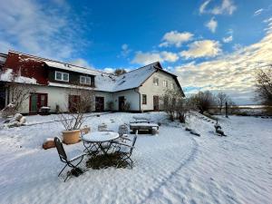 a house with a table and chairs in the snow at Hotel Enddorn Appartement in Grieben