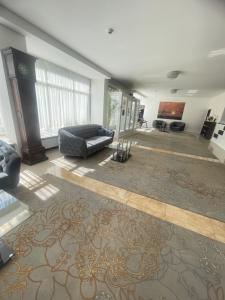 uma sala de estar com um sofá e um tapete em Hotel Parc em Craiova