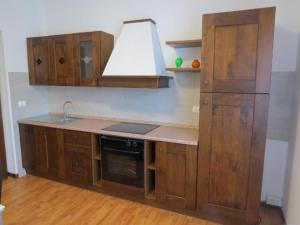 a kitchen with wooden cabinets and a sink and a stove at CASA AZZURRA Domodossola FREE PARKING in Domodossola