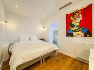 ein Schlafzimmer mit einem Bett und einem Wandgemälde in der Unterkunft Cours Saleya - Wifi, AC, 2pers, aperçu mer in Nizza