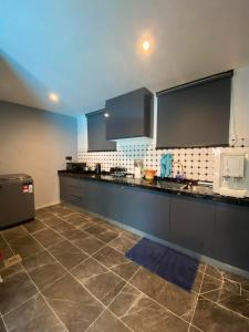 a kitchen with black and white appliances and a tile floor at LYL Jaccuzi Private Pool House in Ipoh