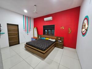 1 dormitorio con cama y pared roja en CM FARM HOUSE, en Sātej