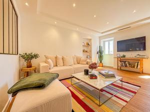 ein Wohnzimmer mit einem Sofa und einem Couchtisch in der Unterkunft Cours Saleya - Wifi, AC, 2pers, aperçu mer in Nizza