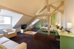 a large attic room with a bedroom and a living room at Hotel International & Terminus in Geneva