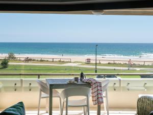 een tafel en stoelen met uitzicht op het strand bij Sandrift Beachfront Apartments in Gold Coast