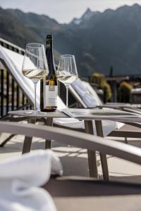 Dois copos e uma garrafa de vinho sentados numa mesa em MYALPS Tirol em Oetz