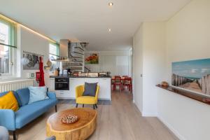 a living room with a couch and a table at Welcome in - Vakantiehuis - Middelburgsestraat 61a - Koudekerke 'Villa Querina' in Koudekerke
