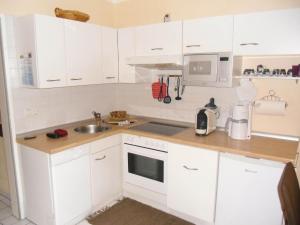 a kitchen with white cabinets and a sink at Ferienwohnung im Ferienpark Falkenstein in Falkenstein