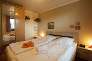 a bedroom with a large bed with an orange towel on it at Ferienwohnung im Ferienpark Falkenstein in Falkenstein