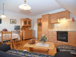 a kitchen with wooden cabinets and a table with flowers at Spacious Apartment with Sauna in Schonsee in Dietersdorf