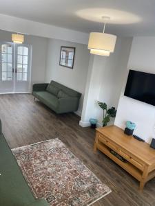 a living room with a couch and a flat screen tv at Heart of Oxford in Oxford
