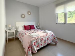 una camera bianca con letto con cuscini rossi di Duna de arenales ad Arenales del Sol