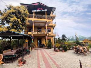 a building with a patio with tables and chairs at Hotel National Park Sauraha- Homely Stay and Peaceful Location with Jungle Safari arrangements in Sauraha