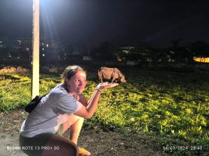 ソーラハにあるHotel National Park Sauraha- Homely Stay and Peaceful Locationの女が背景に象を抱えてフリスビーを捕まえている