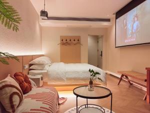 张家界Flower Whisperer Homestay Tianmenshan Store free airport and station pick-up的客厅配有床和平面电视