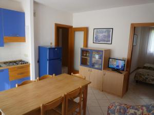 a kitchen and dining room with a table and a blue refrigerator at Le Briccole in Cavallino-Treporti