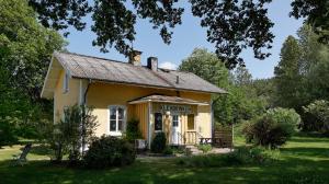 a small yellow building with a sign on it at Skeppsdockans Vandrarhem in Söderköping