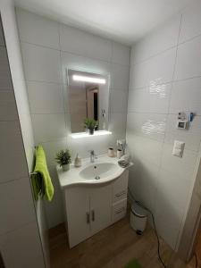 Baño blanco con lavabo y espejo en Ferienwohnung Nina Ortner Greifenburg, en Greifenburg