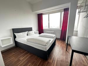 Schlafzimmer mit einem Bett, einem Schreibtisch und einem Fenster in der Unterkunft Ootel.com in Berlin