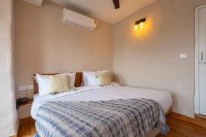 1 dormitorio con 1 cama grande con manta en MAATI - Signature Collection by Eight Continents, en Nainital