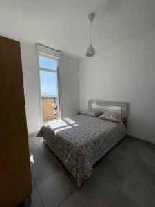 - une chambre avec un lit et une grande fenêtre dans l'établissement Charming T2 with balcony and view of the port, à Marseille