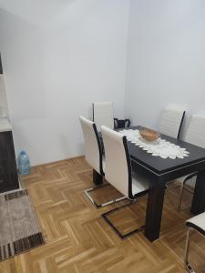 comedor con mesa negra y sillas en Apartman Mia, en Požarevac