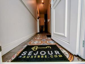 um tapete de boas-vindas no chão em frente a uma porta em Home - Champoulains - Séjour à Auxerre em Auxerre