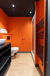 baño de color naranja con aseo y lavamanos en COWOOL TOULOUSE, en Toulouse