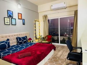 una camera da letto con un letto e una finestra con vista di Sunset View Paradise By Buddies Home a Greater Noida
