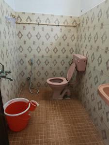 a bathroom with a toilet and a sink and buckets at Paradise Feel Dreamy Resort in Puducherry