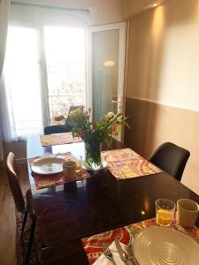 een eettafel met borden en een vaas met bloemen bij Montpellier Gare District in Montpellier