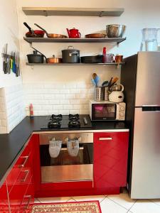 een keuken met rode kasten en een fornuis bij Montpellier Gare District in Montpellier