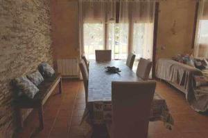 a dining room with a table and a couch at Casa Bellavista con piscina en Caldes Costa Brava in Caldes de Malavella