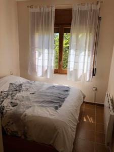 Bett in einem Zimmer mit Fenster in der Unterkunft Casa Bellavista con piscina en Caldes Costa Brava in Caldes de Malavella