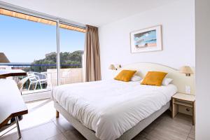 a hotel room with a bed and a balcony at Hotel Centre Plage in Argelès-sur-Mer