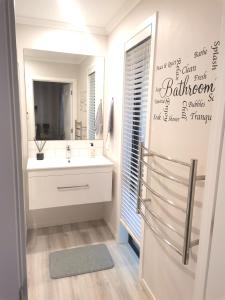 a bathroom with a sink and a mirror at Stylish Private Guest House Ensuite Only in Rolleston