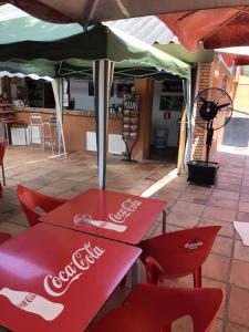 カルデス・デ・マラベーリャにあるCasa Bellavista con piscina en Caldes Costa Bravaのコーカコーラテーブル、椅子(傘下)