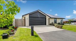 a house with a garage in a driveway at Stylish Private Guest House Ensuite Only in Rolleston