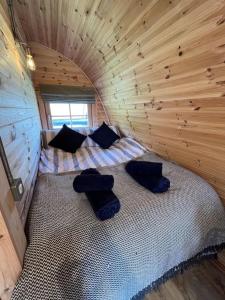 a small room with a bed in a wooden cabin at The Pod Patch - Trelerney Pod in Bishops Castle