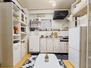 uma cozinha com electrodomésticos brancos e uma mesa em Downtown Tokyo/Taito-gu/2min walk nearest sta/Ueno/Wi-Fi/302 em Tóquio