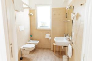 a bathroom with a sink and a toilet and a window at Cufà in Pescara