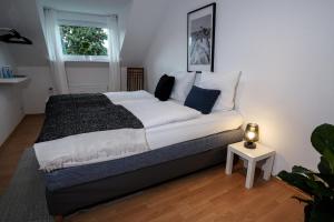 a bedroom with a large bed with white sheets and blue pillows at Stadtoase nähe Uni Design Wohnung mit 2 Schlafzimmern & Sauna in Koblenz